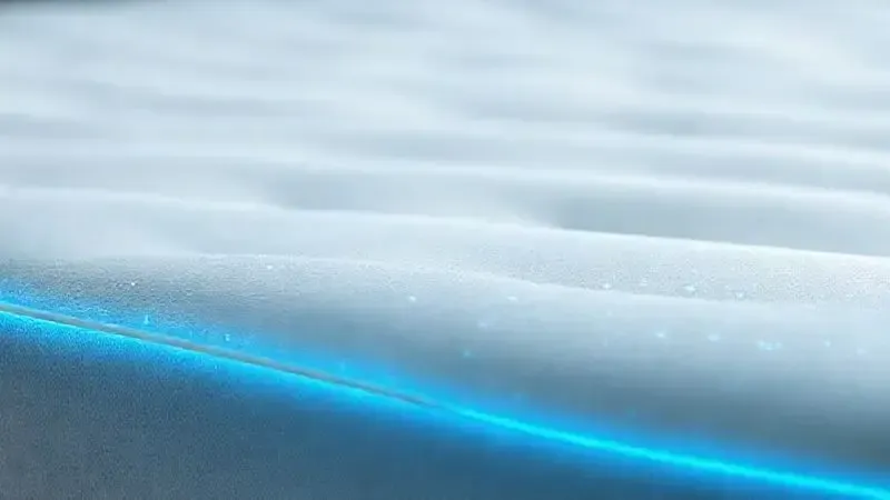 Render artístico de uma superfície de colchão com linhas que representam tecnologia respirável e revestimentos inteligentes para a saúde.