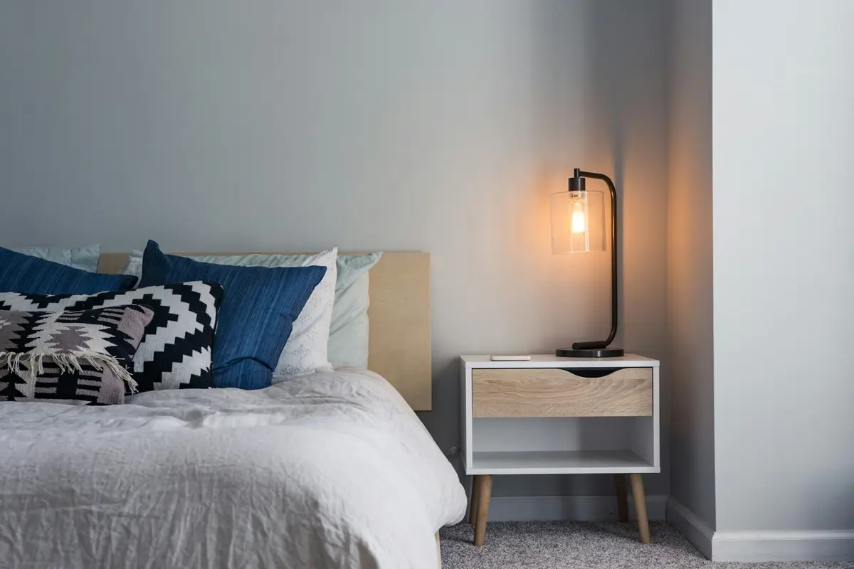Quarto aconchegante com cama de linho branco e iluminação suave